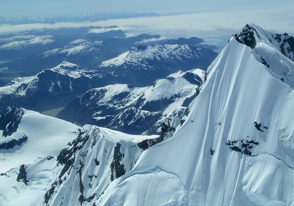 Peak of Mt. Crillon, Fairweather Range, Glacier Bay National Park, Alaska. Late June, early July. 2004. Note the two crevasse lines. Peak height—12, 726 feet/3,879 meters. A week later, these two crevasse lines collapsed. Alaska Airlines pilots flying over saw such clouds from the collapse they initially reported it as a volcano. Photograph by Abigail B. Calkin, 2004.