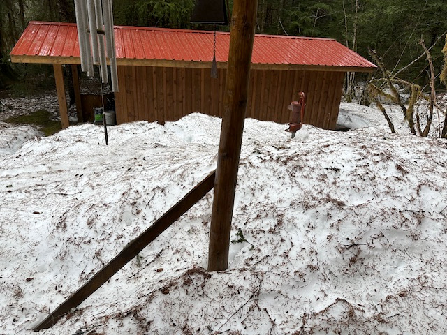 View out to the front porch, which has collapsed from the weight of snow on a 28-year-old porch with a poor foundation. May 1, 2026. It&rsquo;s spruce needles that cover the snow here in this forest.